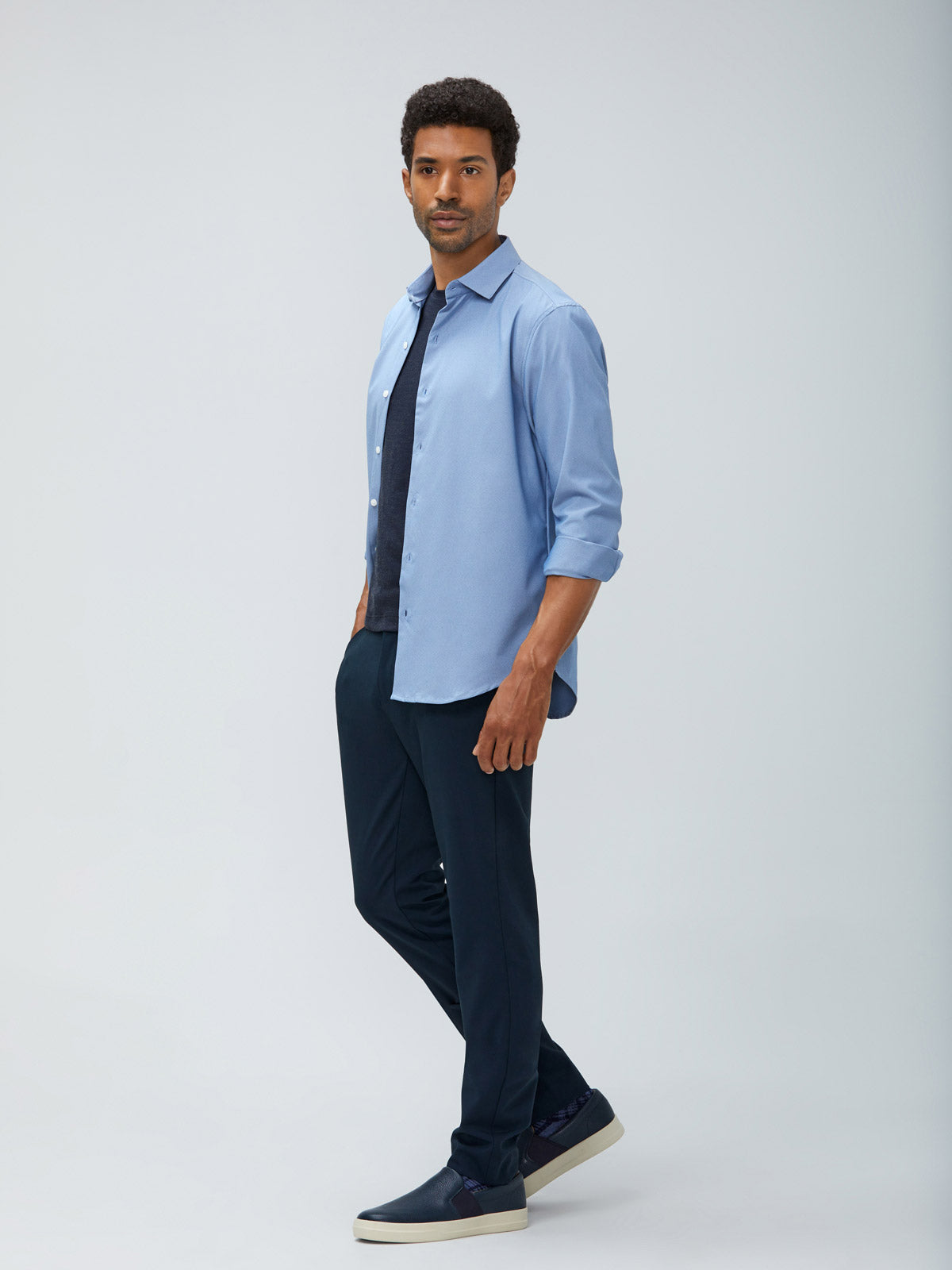 Men's Blue Oxford Aero Zero Dress Shirt and Men's Dark Navy Velocity Pant on model walking left