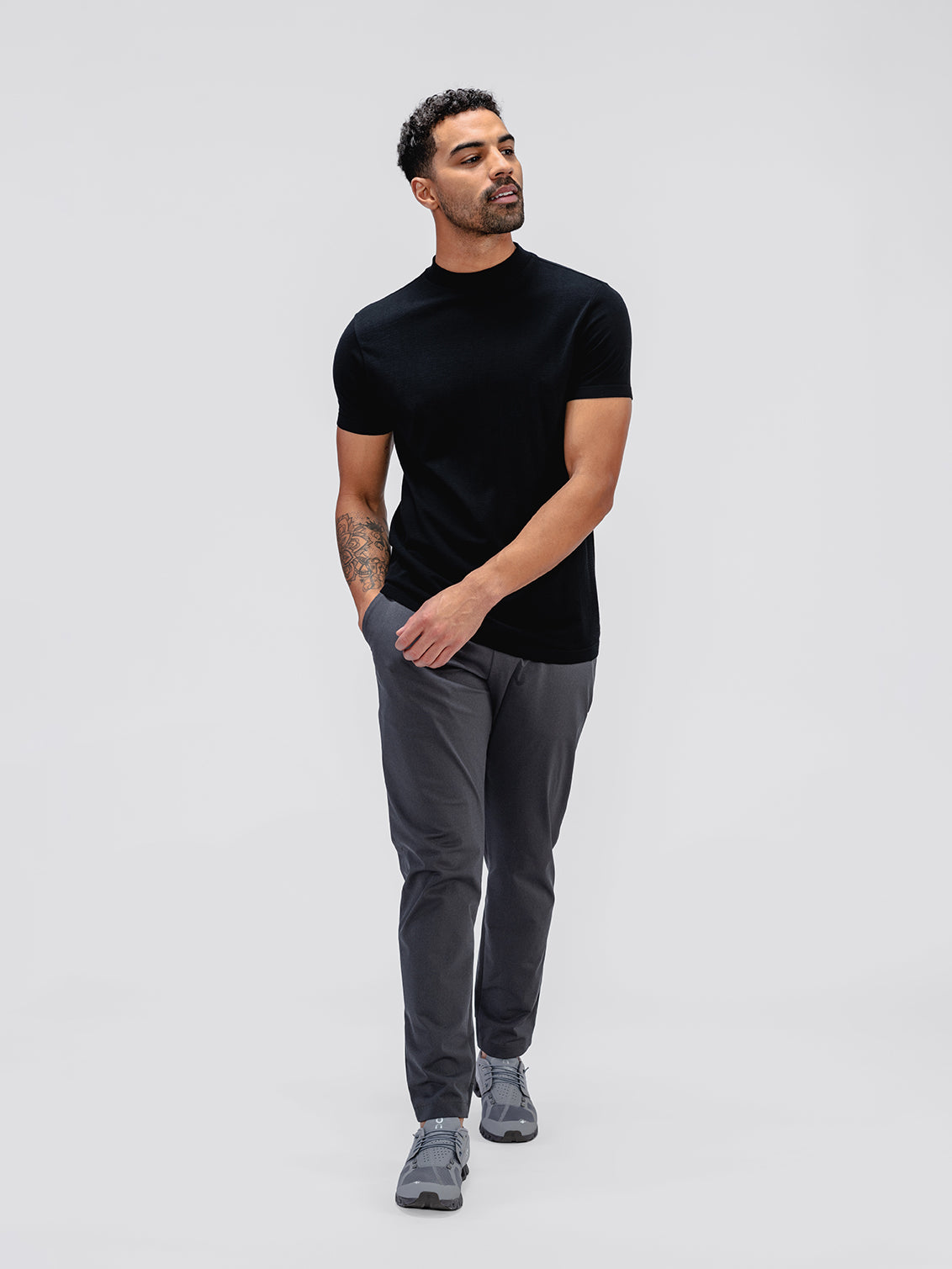 model wearing black atlas high crew tee and charcoal kinetic jogger with hands in pockets