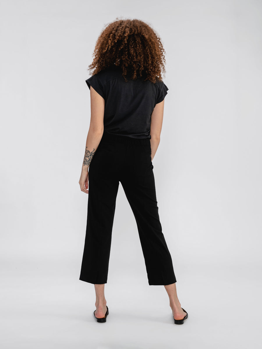 Back of Black Women's Velocity Pull-On Pant and Black Composite Merino V-Neck Tee on model