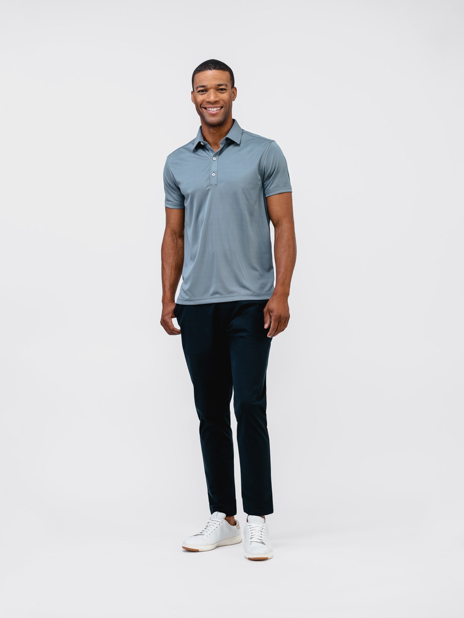 model wearing mens kinetic tapered pant navy and mens apollo polo bright navy oxford front full body