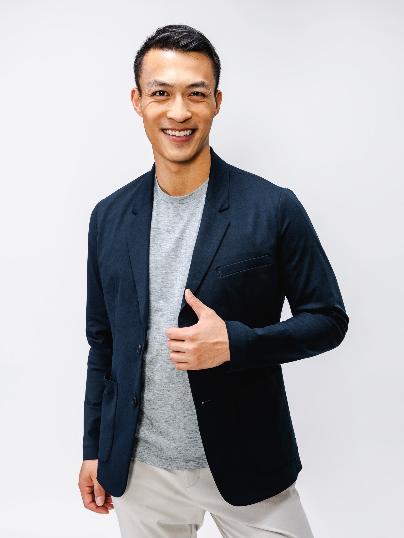 Men's Navy Kinetic Blazer on model adjusting jacket