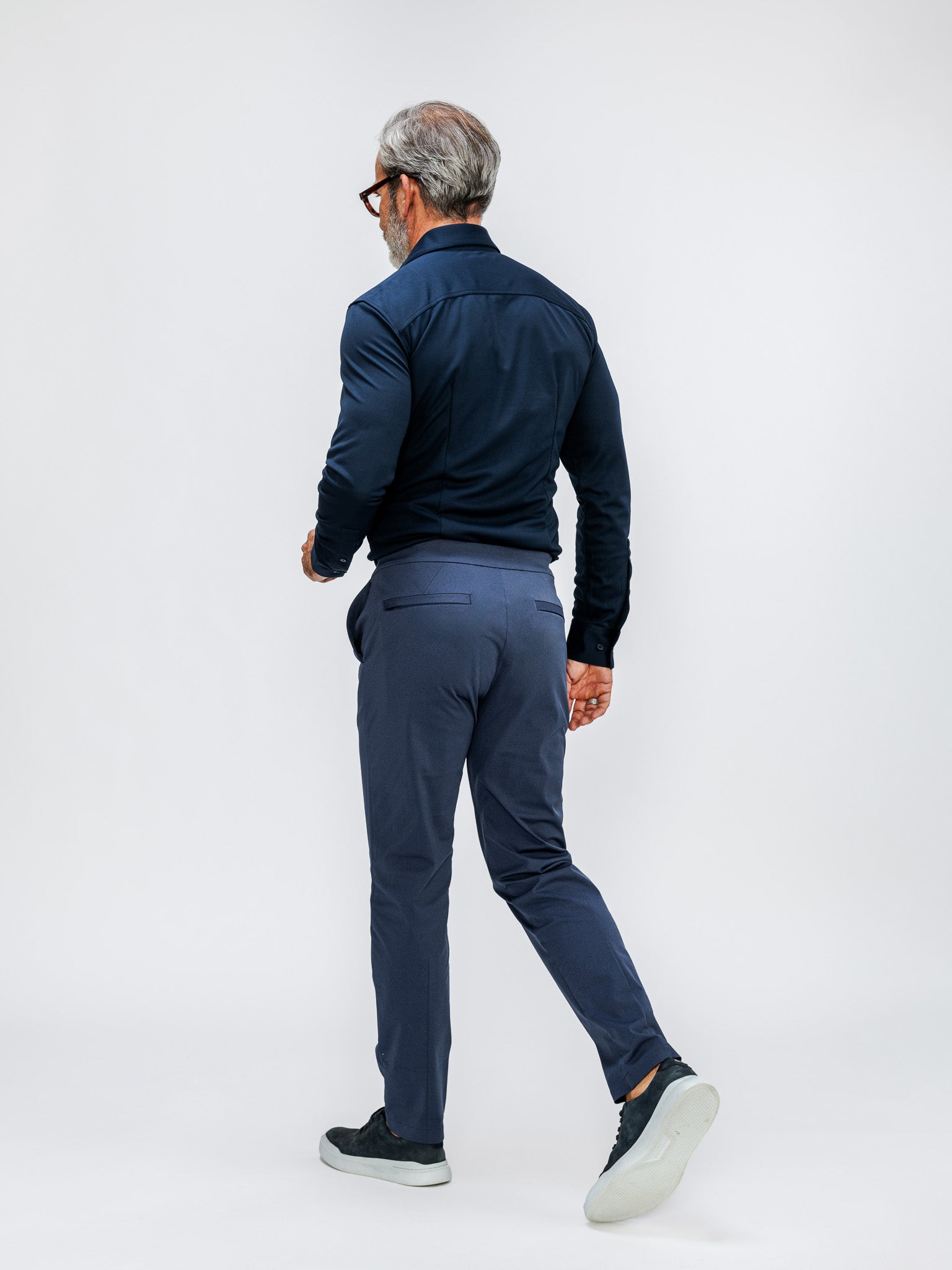 model wearing mens apollo dress shirt navy and mens kinetic pull on pant shadow blue heather on model in studio